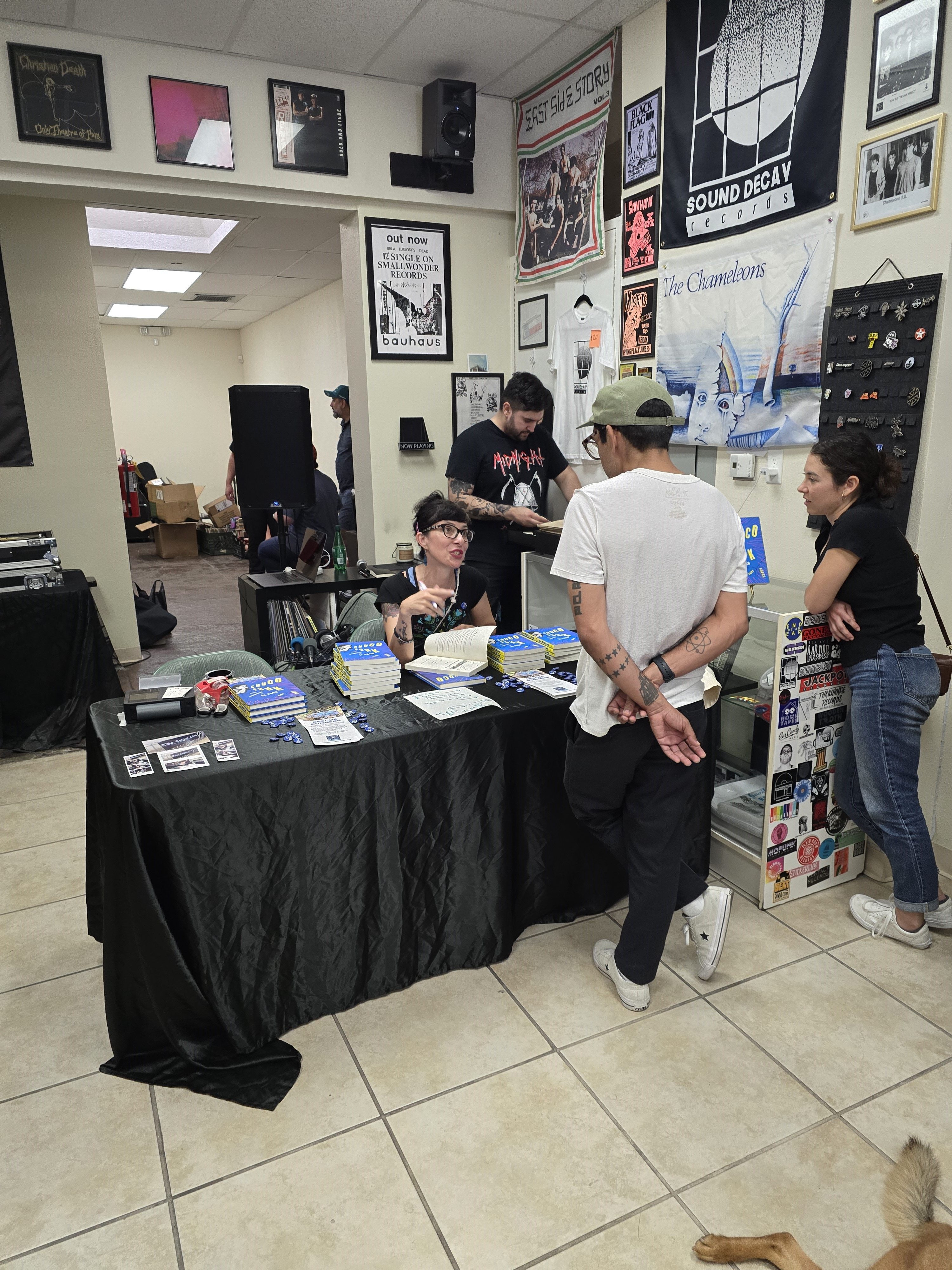 Dr. Tara Lopez at a book signing event in June 2024 at Sound Decay Records in El Paso, TX. She is sitting at a table with books, speaking with fans.