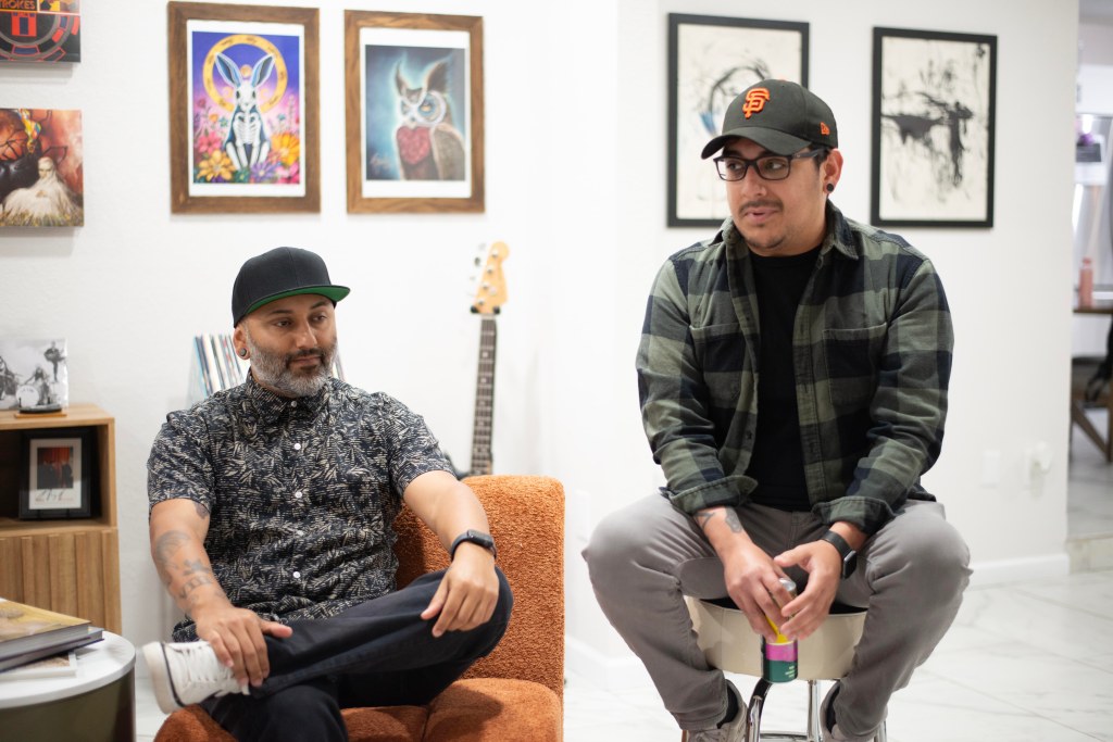 Photo of Bloomwave guitarist Miguel Alcala and vocalist Michael Bol sitting in a living room, discussing the band.